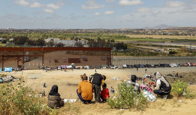 MEX4646. TIJUANA (MÉXICO), 10/05/2023.- Fotografía general donde se observa a migrantes en un campamento junto al muro fronterizo, el 9 de mayo de 2023, en Tijuana, Baja California (México). Tan solo en Tijuana, en la frontera con California, miles de migrantes de diversas nacionalidades, incluyendo familias completas y niños se congregan entre los muros fronterizos días antes de que culmine el Título 42, la noche del jueves, para pedir asilo humanitario en Estados Unidos. El campamento ha ido creciendo desde el fin de semana pasado con personas de Colombia, Venezuela, Perú, Haití, y Honduras, pero también de países lejanos como Turquía y Bosnia, así como mexicanos de los estados sureños de Michoacán y Guerrero, donde la violencia del crimen organizado los desplaza.EFE/Joebeth Terriquez