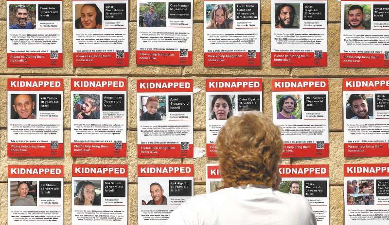 Una mujer en Tel Aviv mira carteles que muestran fotografías de rehenes de Hamás tras el ataque del 7 de octubre.