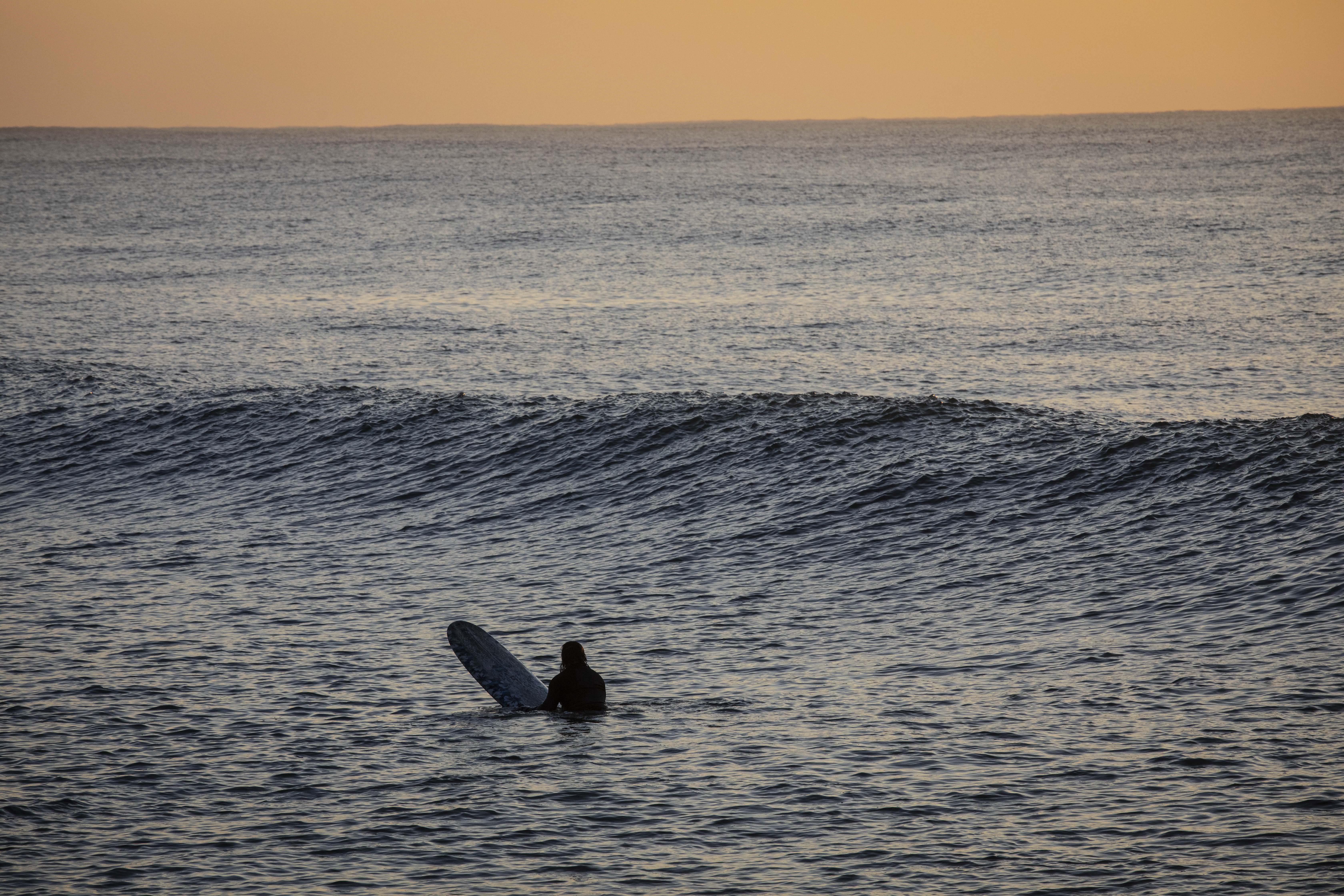 Durban (South Africa), 24/05/2023.- A surfer waits between sets of waves to take their next ride in Durban, South Africa, 24 May 2023. Many surfers start early in the morning as the sun rises in order to ride a good wave before going to work. The east coast city of Durban bordered by the warm Indian Ocean and is popular for surfers, who can surf year round without wet suites. (Sudáfrica) EFE/EPA/KIM LUDBROOK