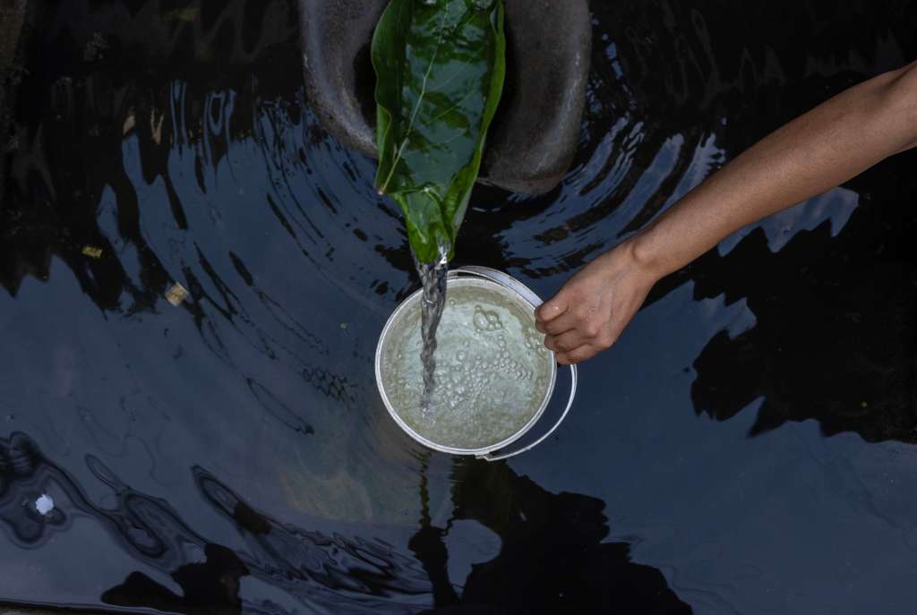 Katmandú (Nepal), 05/06/2024.- Una `persona recoge agua potable de un surtidor de piedra tradicional en Katmandú, Nepal. Katmandú, Lalitpur y Bhaktapur, tres ciudades densamente pobladas que forman parte del valle de Katmandú están experimentando una rápida urbanización. El Día Mundial del Medio Ambiente (WED, por sus siglas en inglés) se celebra en todo el mundo este miércoles.EFE/ Narendra Shrestha