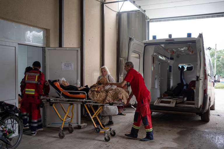 Trabajadores de ambulancia llevan a un residente local a un hospital en la ciudad recuperada de Izyum, Ucrania.