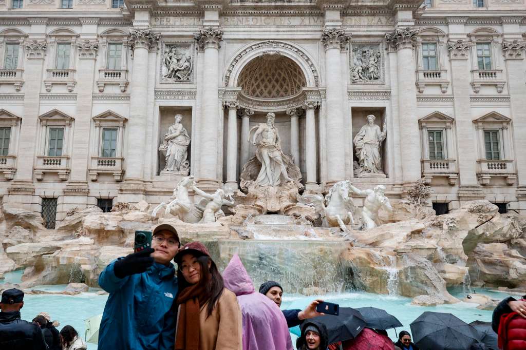 Rome (Italy), 22/12/2024.- People look at the Trevi Fountain and take pictures as it reopens to the public after undergoing maintenance, in Rome, Italy, 22 December 2024. The 18th-century Fontana di Trevi has been cleaned ahead of the Vatican's Holy Jubilee of 2025. (Italia, Roma) EFE/EPA/FABIO FRUSTACI