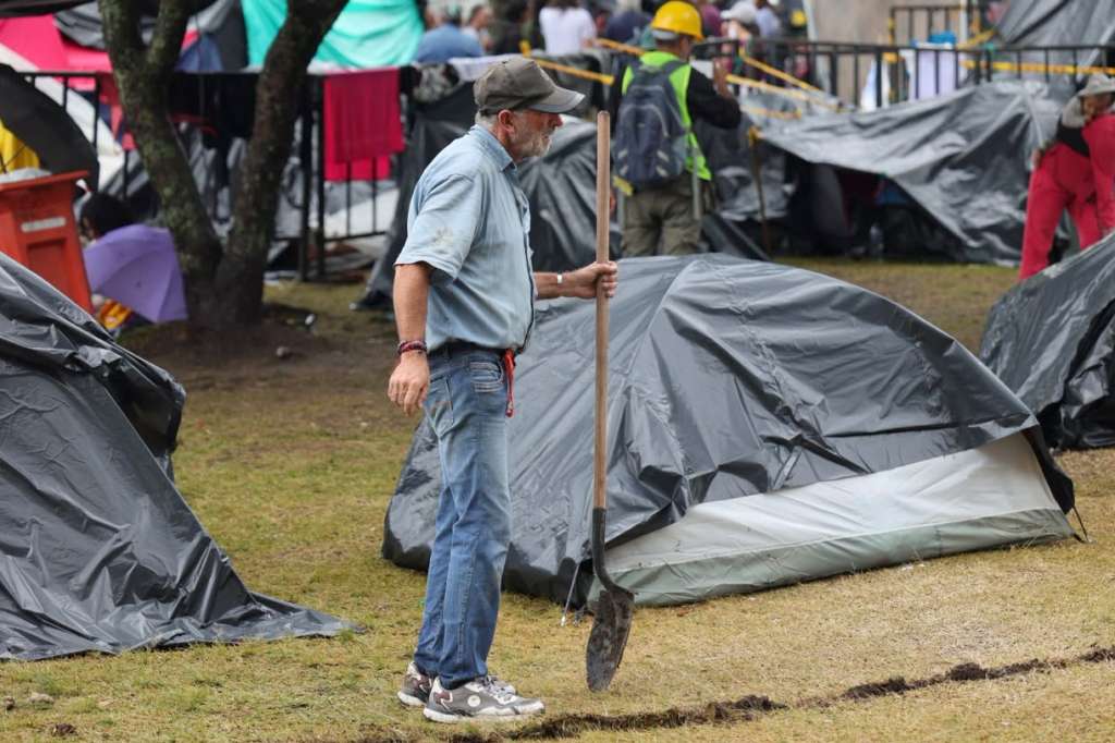 AME9879. PEREIRA (COLOMBIA), 17/08/2026.- Un damnificado por el terremoto de magnitud 7,4, que sacudió Colombia hace una semana, sostiene una pala este lunes, en un campamento ubicado en el parque Olaya Herrera en Pereira (Colombia). EFE/Santiago Gaviria