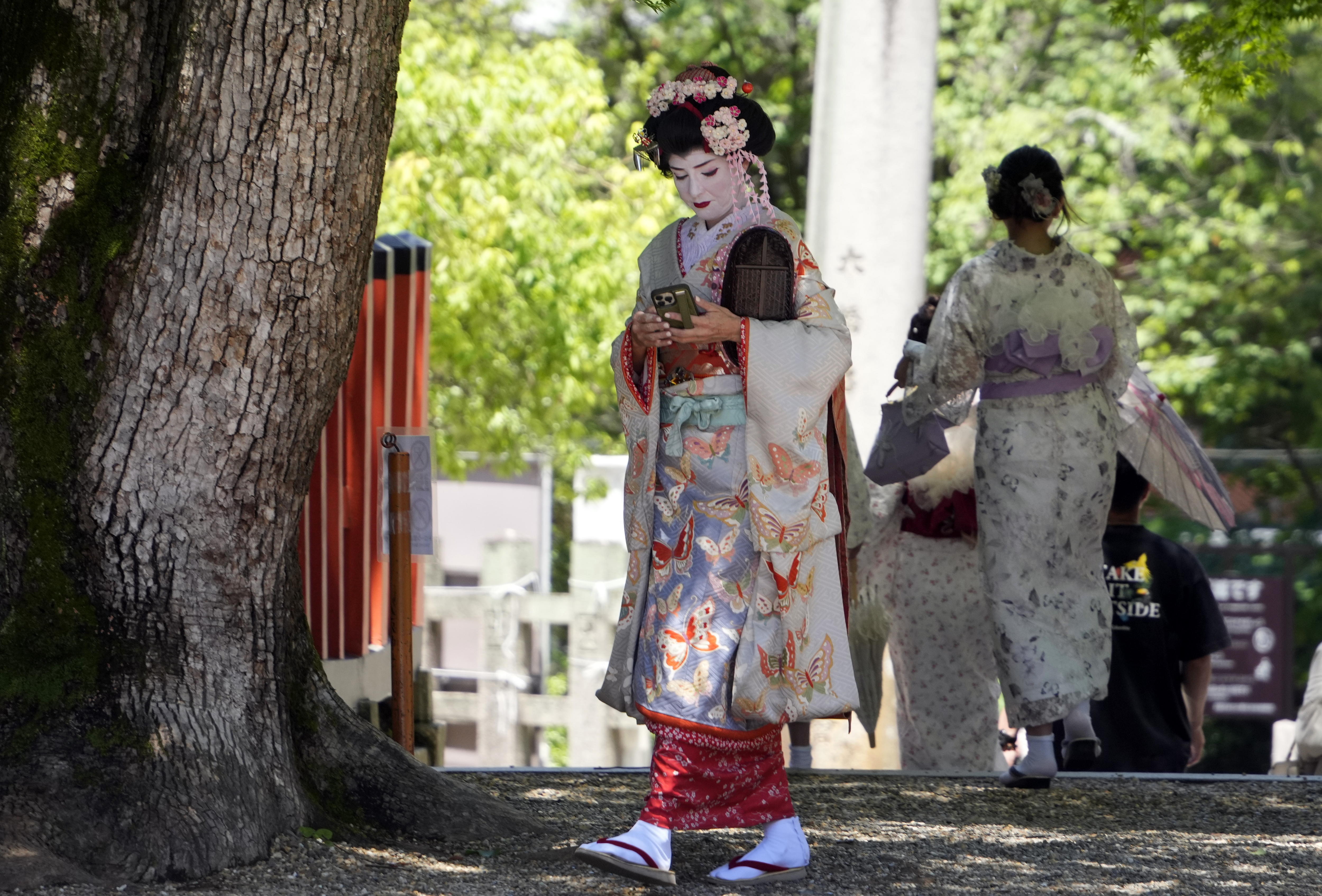 Kyoto (Japan), 29/05/2024.- A foreign tourist dressed as a maiko visits the Yasaka shrine near Gion district in Kyoto, western Japan, 29 May 2024. Gion, the famous Maiko and Geisha district of Kyoto, has begun to apply access restrictions on its streets in the face of overtourism, illustrating Japan's difficulties in dealing with the record number of foreign travelers that the country has been receiving in recent months. (Japón) EFE/EPA/FRANCK ROBICHON