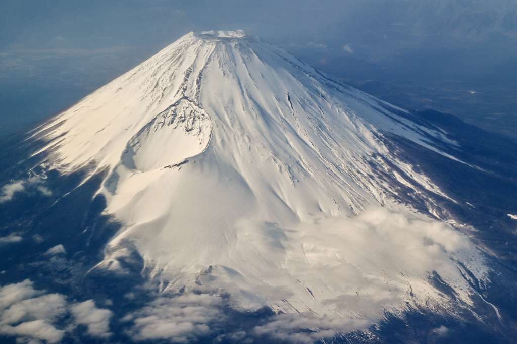 This photo taken on January 30, 2024 shows an aerial view of Mount Fuji, Japan's highest mountain at 3,776 meters (12,389 feet), from the window of a passenger jet.