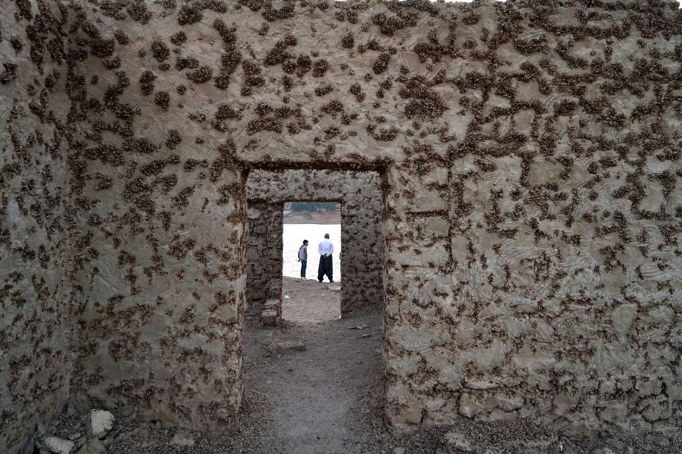 La gente visita los restos de la aldea sumergida de Gary Qasruka abandonada hace 36 años, que han resurgido después de una gran caída en el nivel del agua.