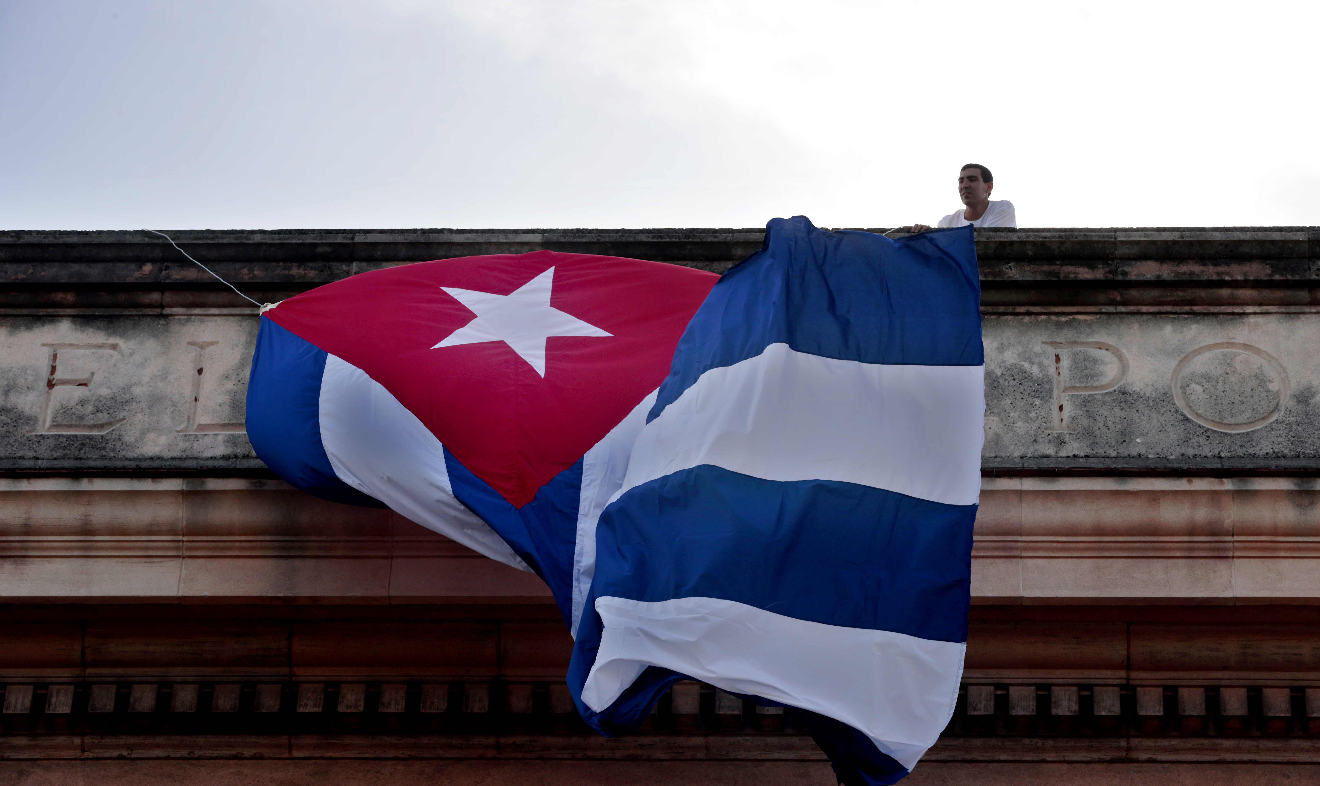 AME954. LA HABANA (CUBA), 03/11/2022.- Un joven coloca una bandera cubana en el techo de una de las facultades de la Universidad de La Habana, donde estudiantes participaron en un acto para ver en una pantalla el discurso del canciller cubano Bruno Rodríguez en la ONU y la votación en contra del Bloqueo de EE.UU. contra Cuba, hoy en La Habana (Cuba). La Asamblea General de la ONU aprobó este jueves una nueva resolución para exigir el fin del embargo estadounidense contra Cuba, en esta ocasión 185 votos a favor, 2 en contra, Estados Unidos e Israel y 2 abstenciones, de Brasil y Ucrania. EFE/Ernesto Mastrascusa