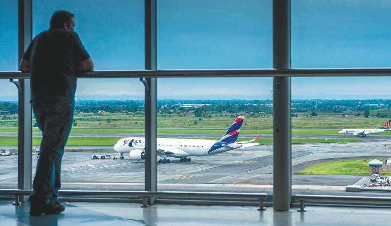 Vista de un avión de la aerolínea Latam desde el interior de un aeropuerto.