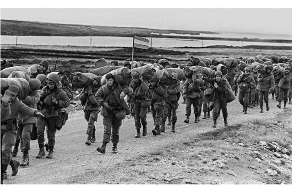 “13 Abril de 1982. Durante la Guerra de las Malvinas, un grupo de soldados argentinos caminan rumbo a Puerto Argentino, una zona que para entonces estaba capturada por los soldados británicos.. / AFP”