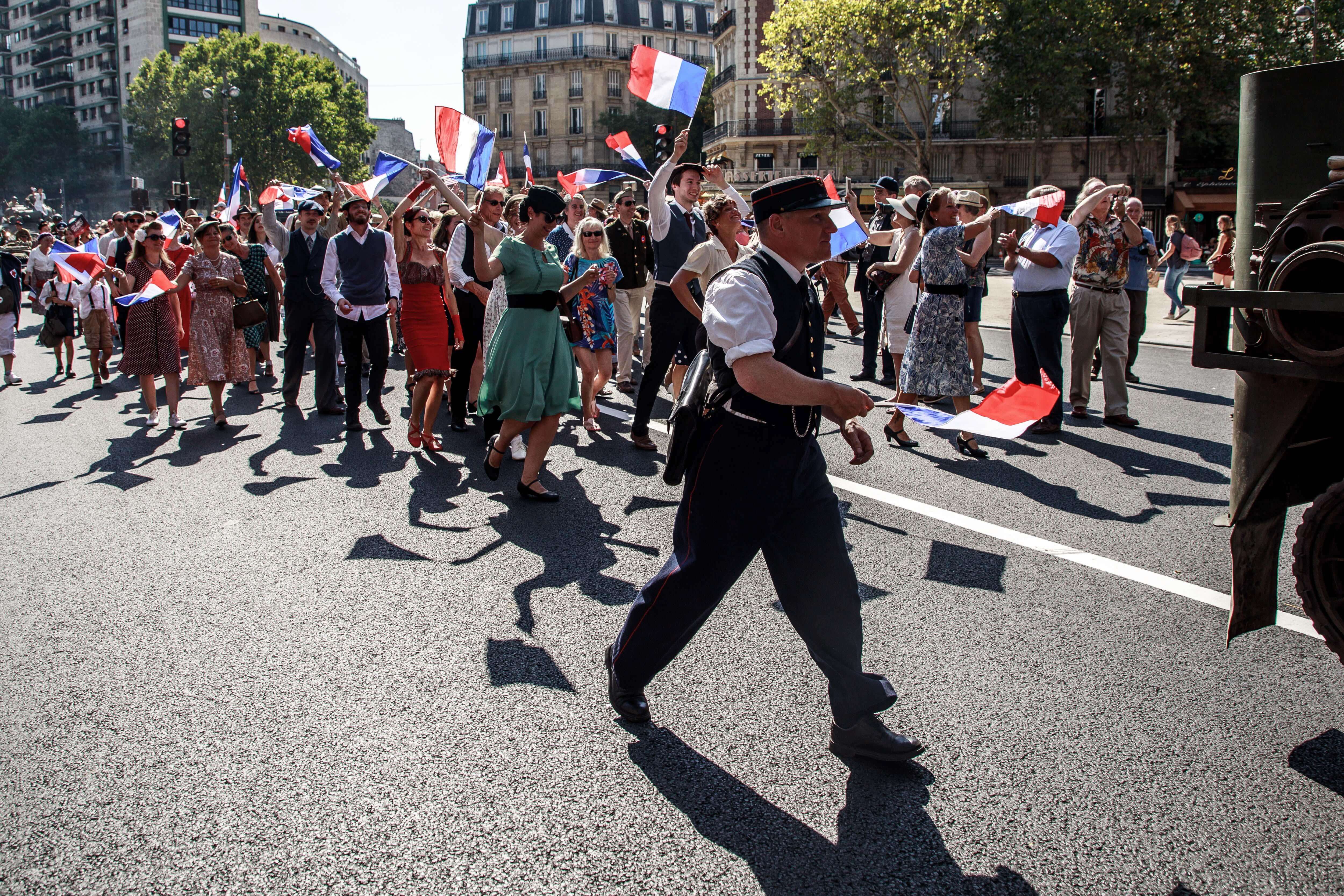 Participantes del desfile se vistieron como civiles franceses durante la Segunda Guerra Mundial para conmemorar el 75 aniversario de la liberación de París de los nazis.  / EFE