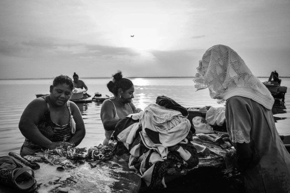Las mujeres conversan sobre sus anhelos y angustias mientras lavan la ropa a la orilla de la ciénaga.