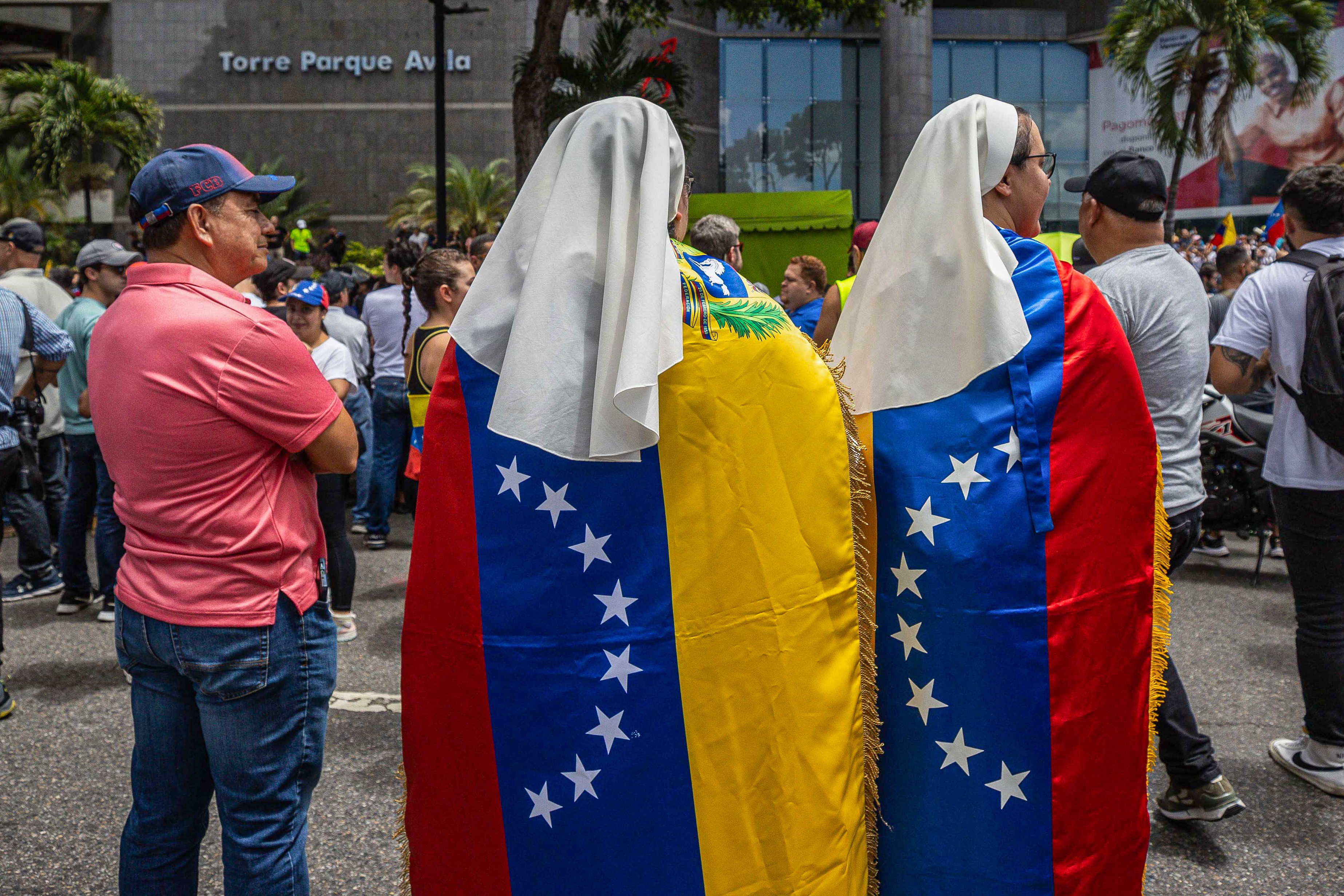 AME6559. CARACAS (VENEZUELA), 30/07/2024.- Dos monjas usan banderas de Venezuela durante una manifestación de apoyo al candidato a la presidencia de Venezuela Edmundo González Urrutia este martes, en Caracas (Venezuela). Miles de venezolanos se han concentrado en Caracas, en un acto convocado por la oposición mayoritaria, para rechazar por segundo día consecutivo lo que consideran es un fraude en los resultados oficiales del Consejo Nacional Electoral (CNE), que en la víspera proclamó a Nicolás Maduro como presidente reelecto con el 51,2 % de los votos. EFE/ Henry Chirinos