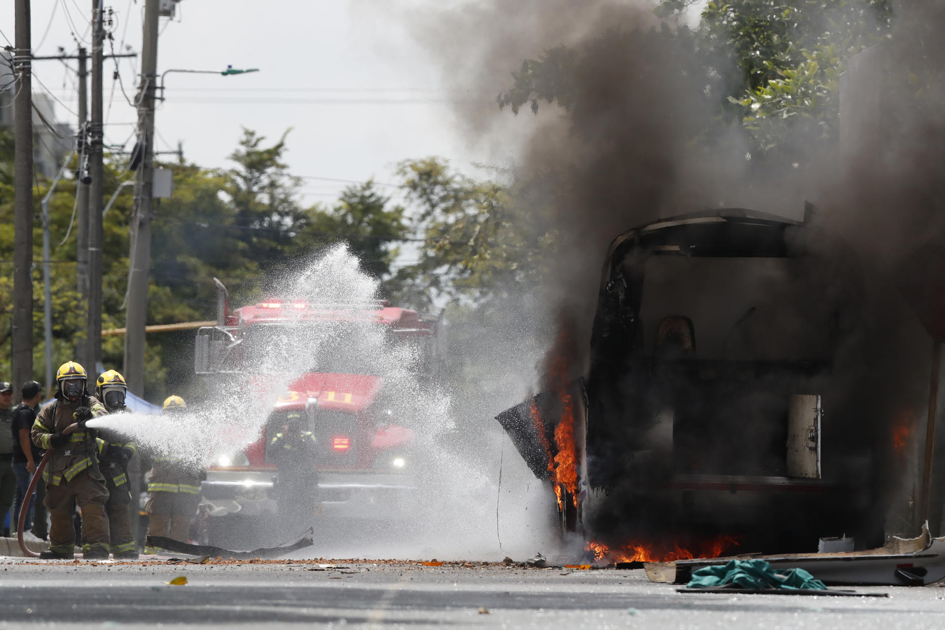 FOTODELDÍA AME6392. CALI (COLOMBIA), 24/04/2026.- Integrantes del cuerpo de bomberos apagan el fuego en un vehículo afectado por una explosión este viernes, en inmediaciones del batallón de la Tercera Brigada del Ejército en Cali (Colombia). EFE/ Ernesto Guzman Jr