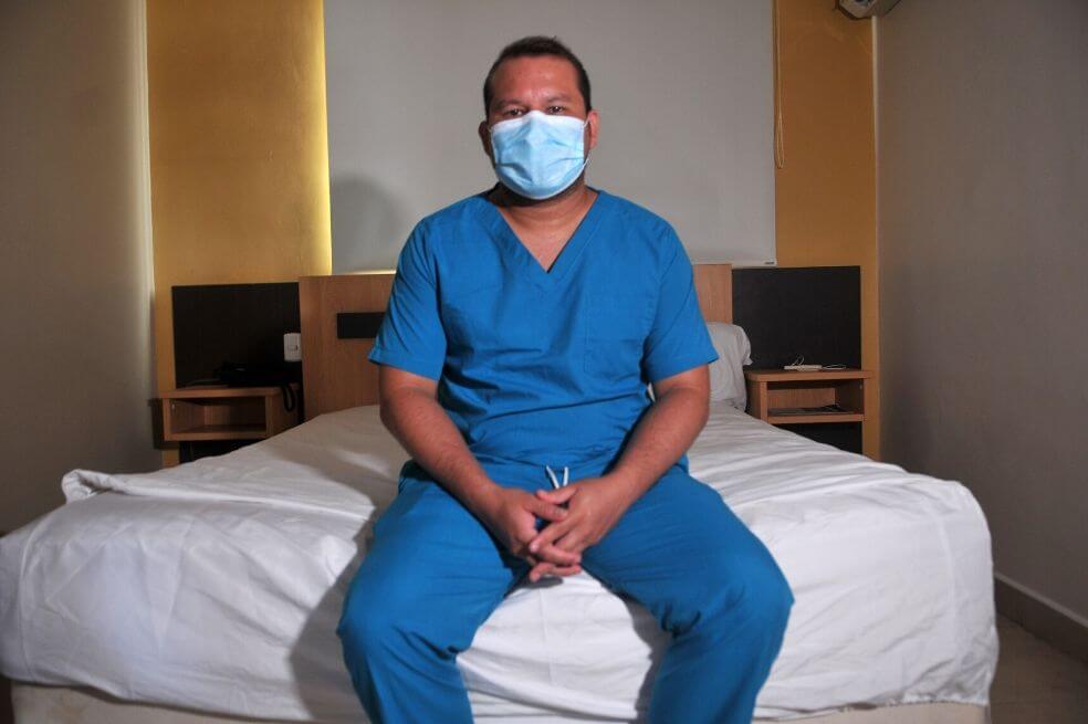 El médico ecuatoriano Javier Palacios posa en su habitación de un hotel donde los trabajadores de salud permanecen aislados en el norte de Guayaquil, Ecuador. / AFP