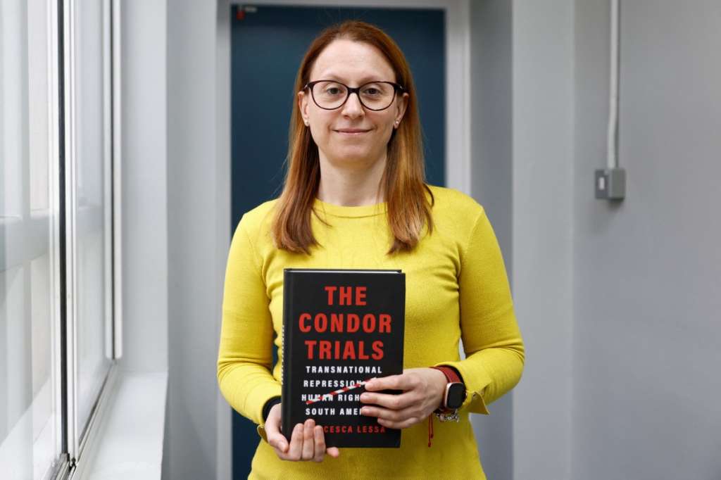 This photo taken on March 6, 2026 shows Italian professor and author Francesca Lessa posing with her book, 'The Condor Trials', at her office in London.
