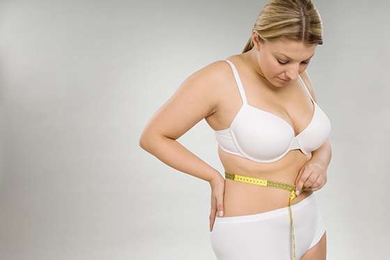 A woman measuring her waist