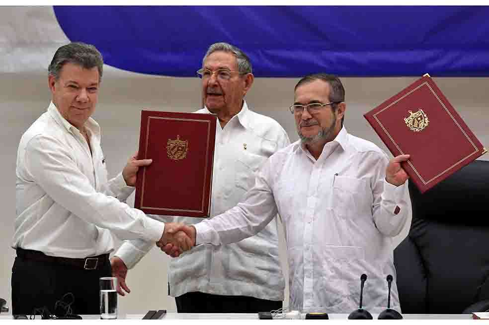 El delegado de las Farc en La Habana, Rodrigo Londoño Echeverri, alias "Timochenko", el presidente de Colombia, Juan Manuel Santos y el presidente de Cuba, Raúl Castro . / EFE