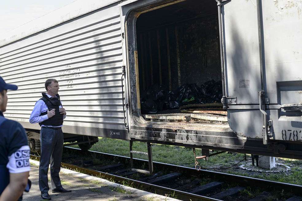 Monitores de la Organización para la Seguridad y la Cooperación en Europa inspeccionan el tren con los cuerpos. / AFP