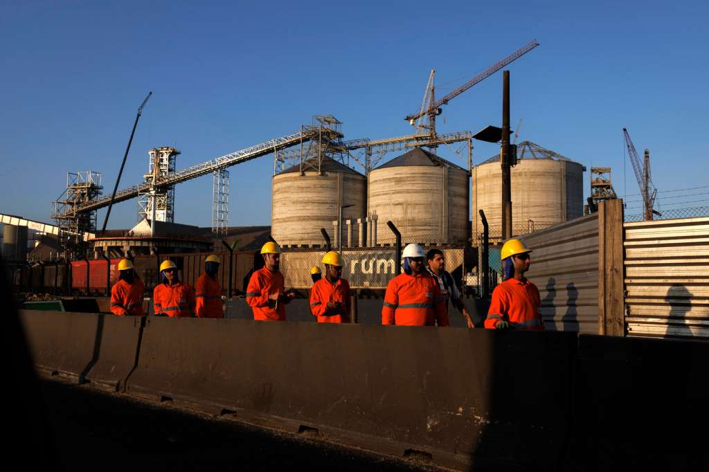 AME3045. SANTOS (BRASIL), 16/07/2025.- Fotografía de trabajadores este martes, en el puerto de Santos (Brasil). En el puerto de Santos, el mayor atracadero comercial de América Latina, observan con "gran preocupación" la inminente entrada en vigor del arancel del 50 % anunciado por el presidente de Estados Unidos, Donald Trump. EFE/ Isaac Fontana
