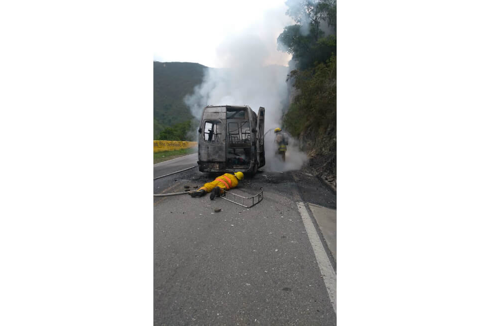 Bomberos apagando la camioneta incinerada. / Cortesía
