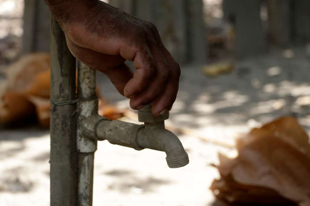 ACOMPAÑA CRÓNICA: COLOMBIA SEQUÍA AME3661. GUATACA (COLOMBIA), 30/03/2024.- Un hombre abre un grifo para tratar de obtener agua, el 27 de marzo de 2024, en la población de Gautaca, corregimiento del municipio de Santa Cruz de Mompox (Colombia). En Guataca, un caserío del departamento colombiano de Bolívar, de calles tórridas y polvorientas, rodeado por una gran riqueza hídrica, no hay agua potable para consumo por una prolongada sequía que obliga a su gente a abastecerse en un arroyo que está prácticamente seco y cubierto por la maleza. EFE/Ricardo Maldonado Rozo