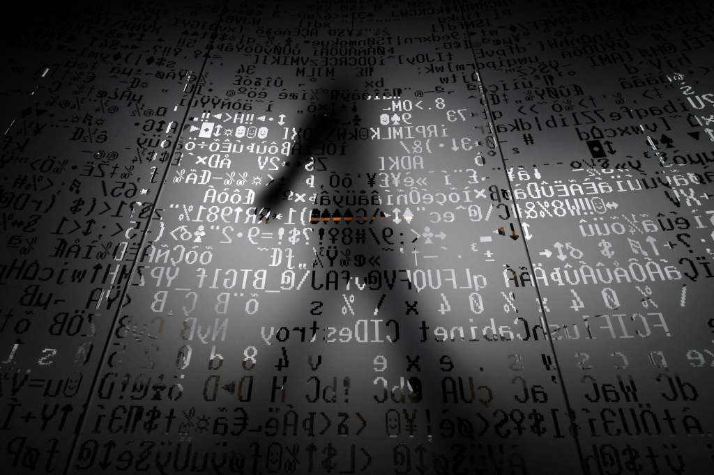 (FILES) A picture taken on October 17, 2016 shows an employee walking behind a glass wall with machine coding symbols at the headquarters of Internet security giant Kaspersky in Moscow.