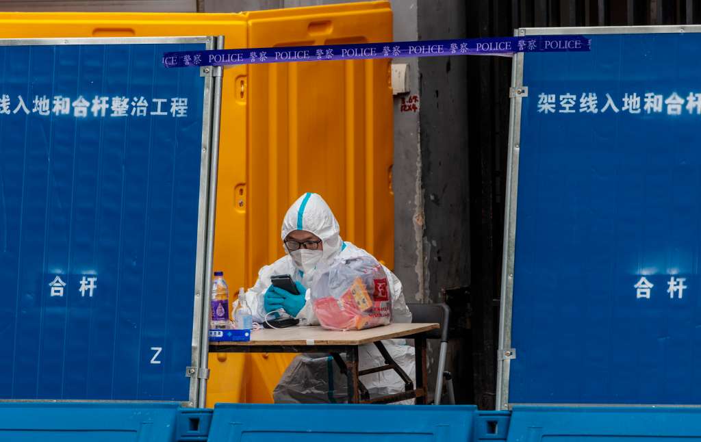 Shanghai (China), 31/03/2022.- A man wearing protective gear guards in front of the compound under quarantine amid the lockdown, in Puxi side of the city, in Shanghai, China, 31 March 2022. Shanghai city imposed a strict lockdown amid the COVID-19 resurgence. A complete lockdown hits the two biggest areas in the city, divided by the Huangpu River. East of the Huangpu River, Pudong area, lockdown started on 28 March while west area, Puxi, will have a lockdown from 01 April. EFE/EPA/ALEX PLAVEVSKI