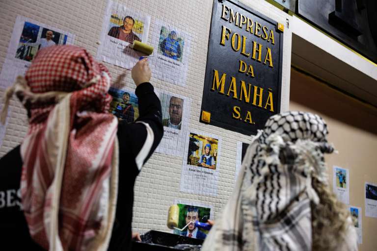 AME5845. SAO PAULO (BRASIL), 07/10/2025.- Personas colocan imágenes de periodistas muertos en Gaza, frente a la sede del diario Folha este martes, en Sao Paulo (Brasil). Manifestantes en apoyo a la flotilla de activistas que partió a la Franja de Gaza se reunieron en una protesta por la forma en que la prensa brasileña ha abordado el conflicto entre Israel y Palestina. EFE/ Isaac Fontana