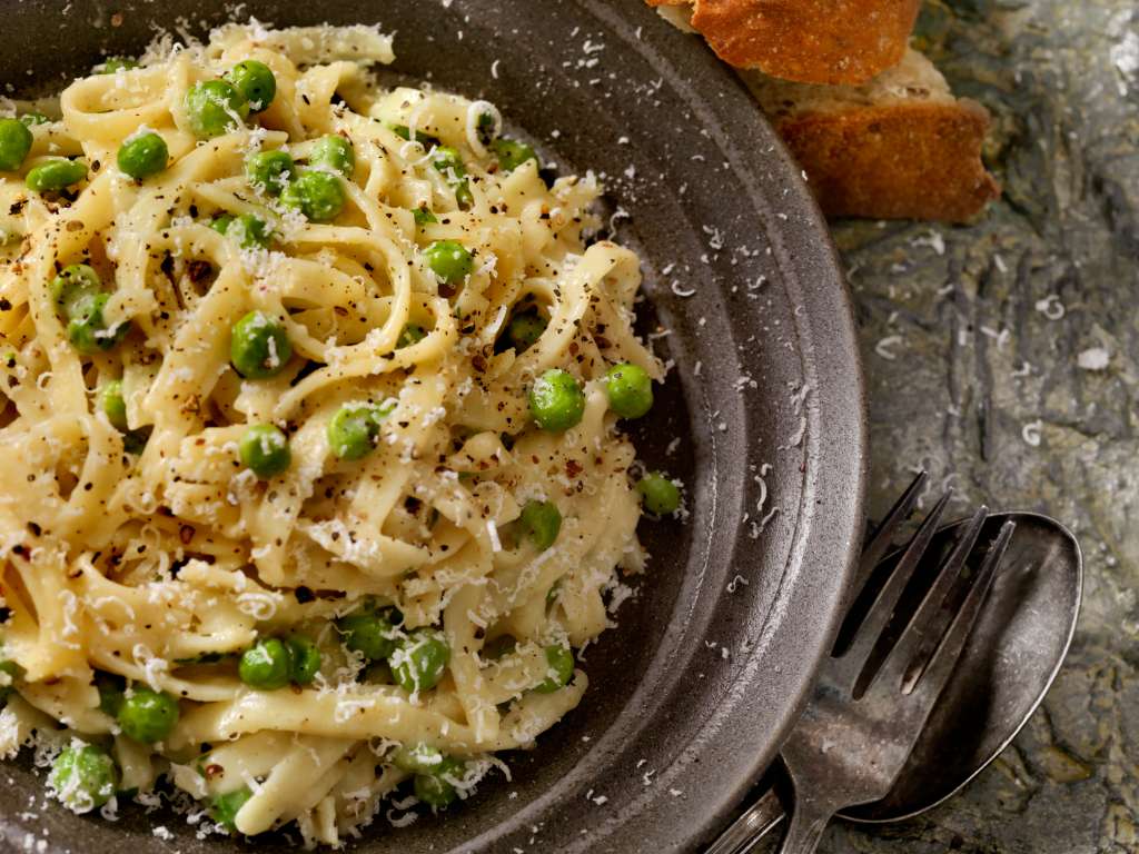 Pasta Alfredo con arvejas, tocineta y mozzarella