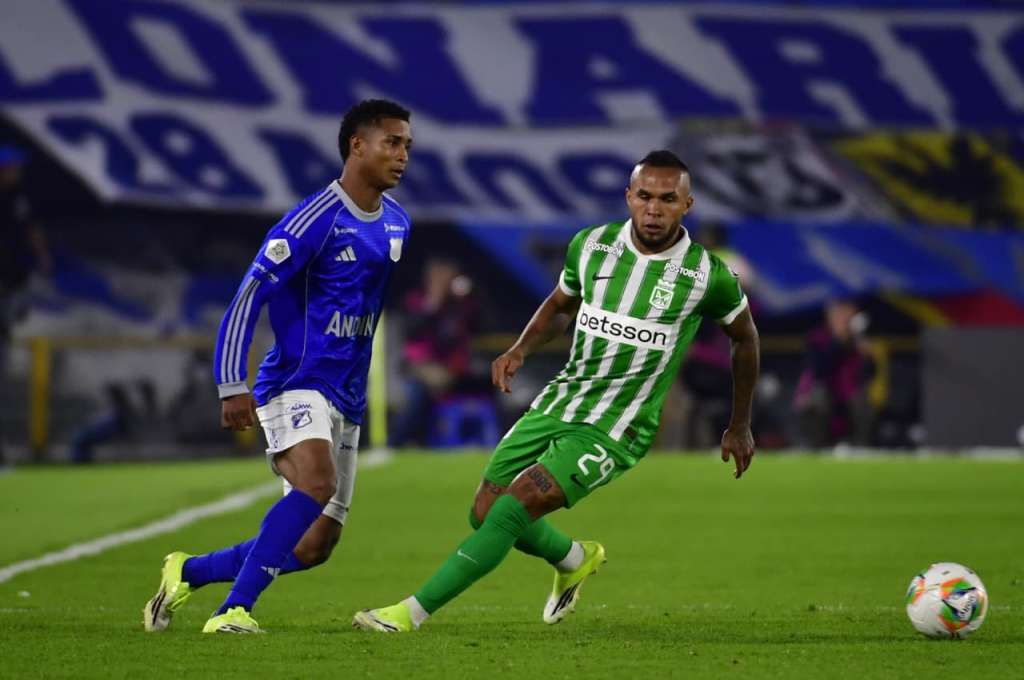 Carlos Sarabia (Millonarios) pasa la pelota ante la mirada de Andrés Sarmiento (Atlético Nacional).