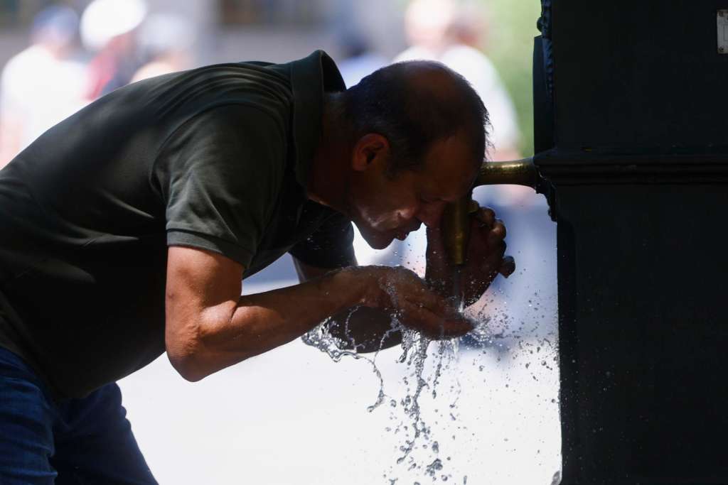 BARCELONA, 28/06/2025.- Un hombre se refresca en una fuente en Barcelona este sábado. Catorce comunidades están este sábado en alerta por temperaturas excepcionalmente altas en el día de inicio de la primera ola de calor del verano en España. EFE/Quique García