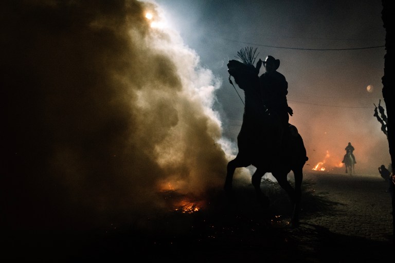 FOTOGALERÍA 1 DE 10.- SAN BARTOLOMÉ DE PINARES (ÁVILA), 16/01/2023.- Un jinete pasa con su caballo por encima de las llamas durante las tradicionales "luminarias" que se celebran hoy lunes en la localidad abulense de San Bartolomé de Pinares. EFE / Raúl Sanchidrián.