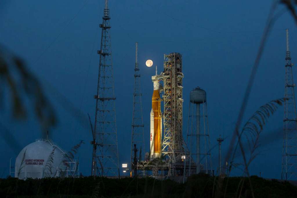USA9310. MERRITT ISLAND (ESTADOS UNIDOS), 20/07/2022.- Fotografía del 14 de junio de 2022, cedida por la NASA, donde se aprecia la luna llena detrás del cohete del Sistema de lanzamiento espacial (SLS) Artemis I que lleva en lo alto la nave espacial Orion, en el Complejo de Lanzamiento 39B del Centro Espacial Kennedy, en Merritt Island, Florida (EE.UU.). Los responsables en la NASA de la misión Artemis I esperan que el despegue se realice a finales de agosto o principios de septiembre de 2022, lo que significaría el primer paso para establecer presencia humana duradera en la Luna mientras se prepara el salto a Marte. EFE/ NASA/ SÓLO USO EDITORIAL/SÓLO DISPONIBLE PARA ILUSTRAR LA NOTICIA QUE ACOMPAÑA (CRÉDITO OBLIGATORIO)
