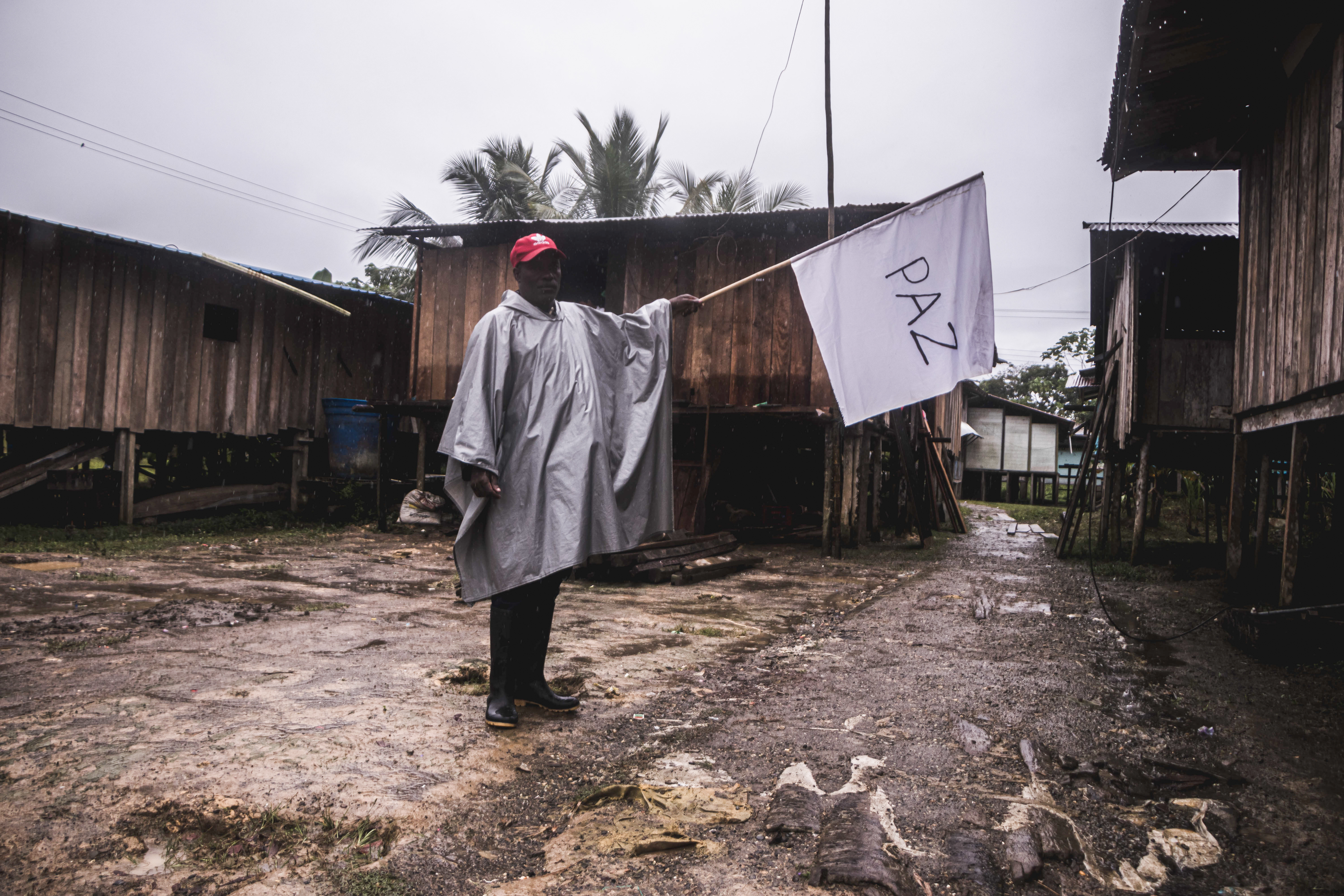 Un habitante del río San Juan sostiene una bandera blanca en medio de la misión humanitaria con acompañamiento de la iglesia, que recorrió la zona en octubre de 2021.
