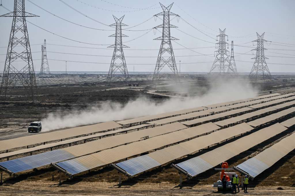 (FILES) This photograph taken on January 12, 2024, shows workers installing solar panels at the Adani Group owned Khavda Renewable Energy Park in Khavda.