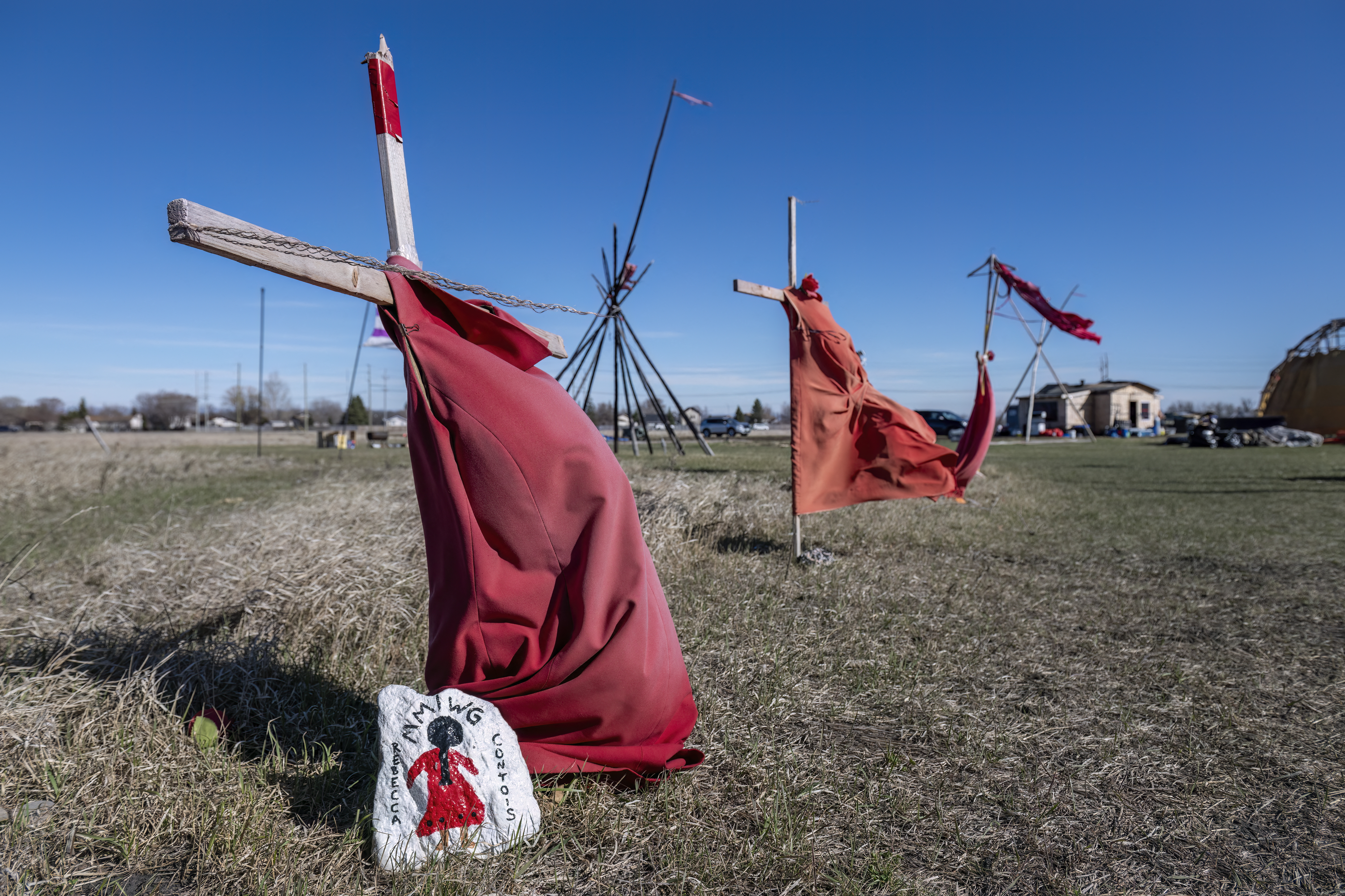 Red dresses on crosses are displayed at the entrance of a makeshift camp near near the Prairie Green landfill in Winnipeg, Manitoba, Canada, on April 27, 2024.