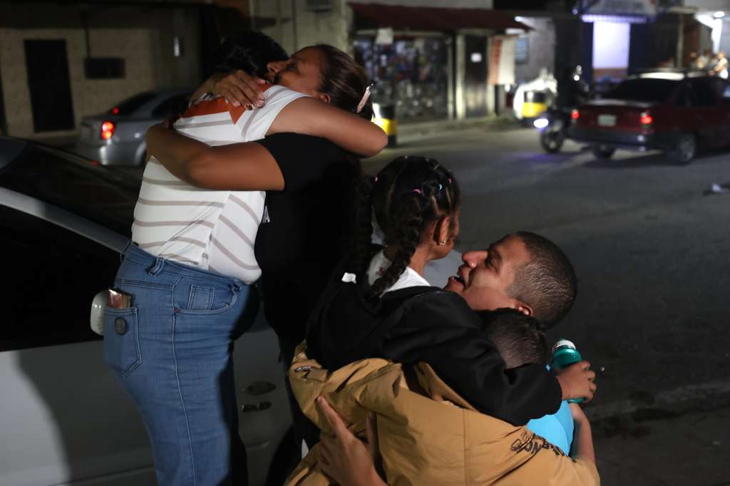 AME9170. GUATIRE (VENEZUELA), 14/08/2026.- Leomar Guerra abraza a sus hijos tras ser excarcelado del centro penitenciario Rodeo 1 este viernes, en Guatire (Venezuela). Al menos 40 presos políticos fueron excarcelados, informó la ONG Foro Penal, líder en la defensa legal de estos detenidos, un hecho que se da dos días después de haber culminado la primera ronda de negociaciones entre el chavismo y un sector de la oposición liderado por la exdiputada Dinorah Figuera. EFE/ Ronald Peña R