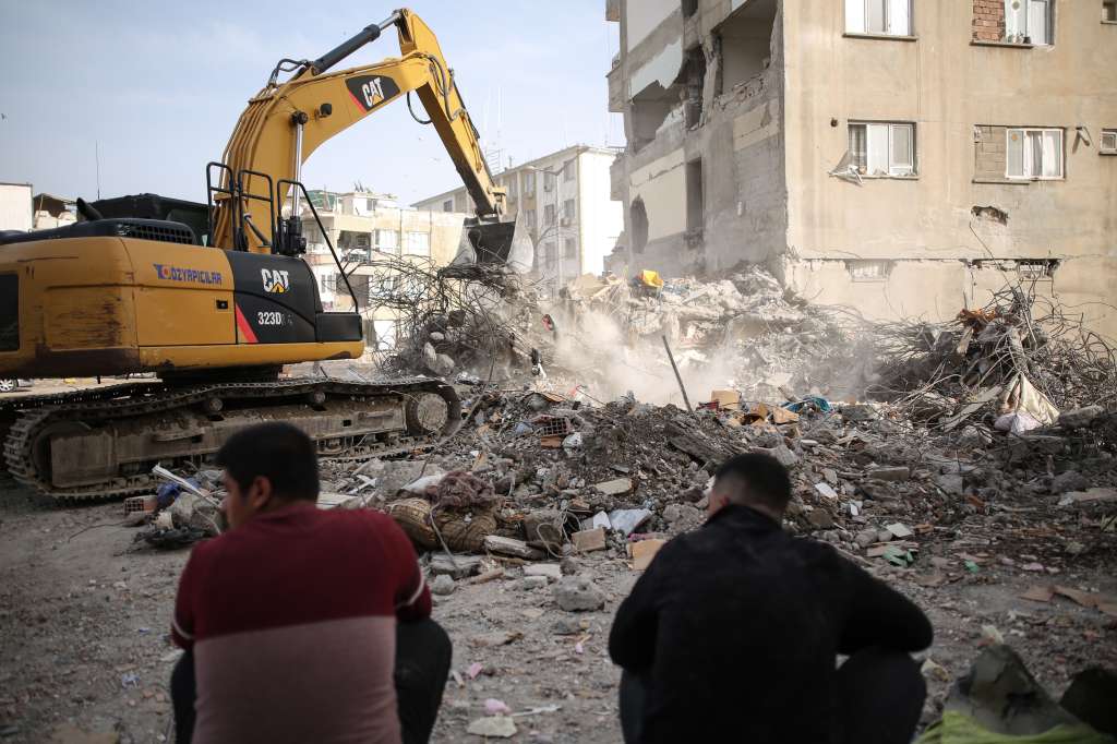 Adiyaman (Turkey), 28/02/2023.- People sit in front of a collapsed building after a powerful earthquake in Adiyaman, Turkey, 28 February 2023. More than 50,000 people died and thousands more were injured after major earthquakes struck southern Turkey and northern Syria on 06 February and again on 20 February. (Terremoto/sismo, Siria, Turquía, Estados Unidos) EFE/EPA/STR