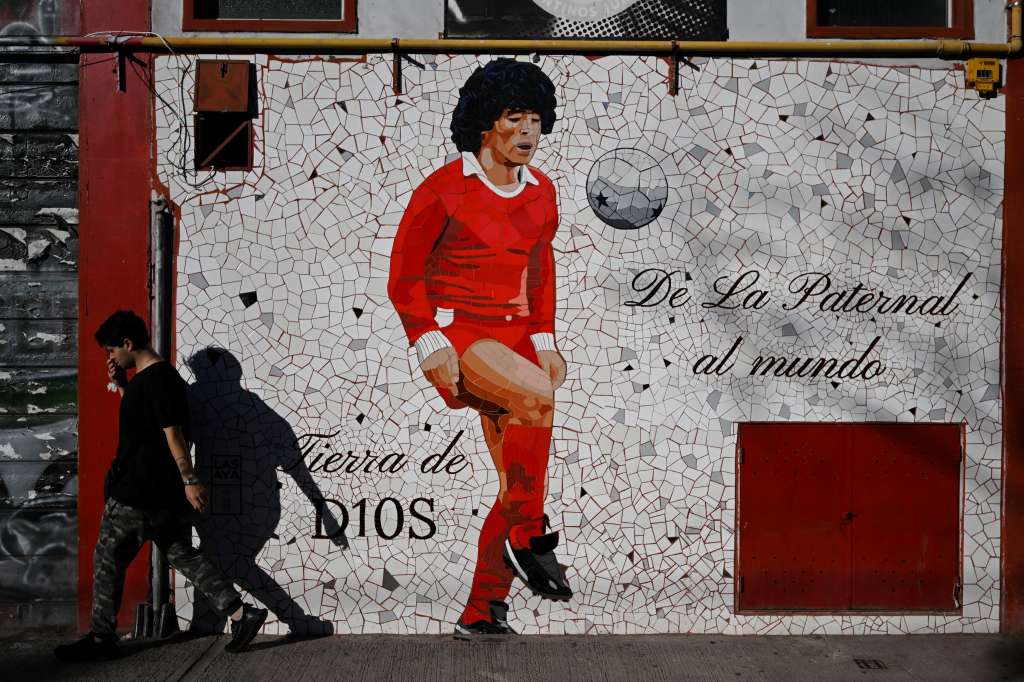 TOPSHOT - A man walks past a mural depicting late Argentine football legend Diego Maradona outside the Diego Armando Maradona stadium, home of the Argentine football team Argentinos Juniors at La Paternal neighborhood in Buenos Aires on March 10, 2025.