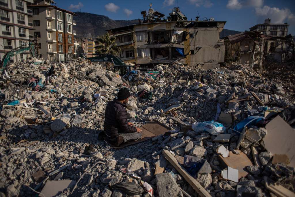 Hatay (antakya) (Turkey), 19/02/2023.- A man prays on debris of collapsed buildings after a powerful earthquake, in Hatay, Turkey, 19 February 2023. More than 46,000 people have died and thousands more are injured after two major earthquakes struck southern Turkey and northern Syria on 06 February. Authorities fear the death toll will keep climbing as rescuers look for survivors across the region. (Terremoto/sismo, Siria, Turquía, Estados Unidos) EFE/EPA/MARTIN DIVISEK