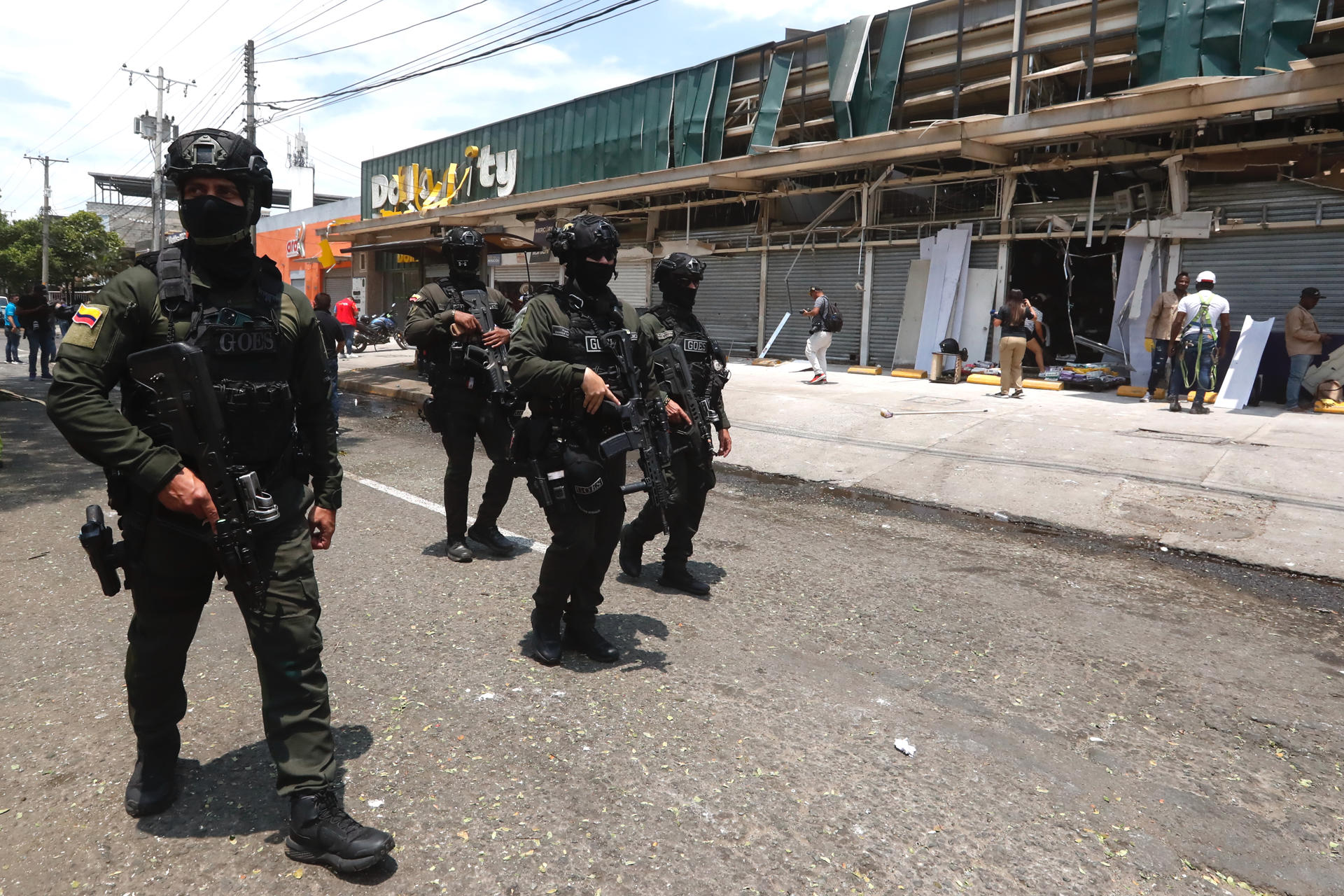 AME2806. CALI (COLOMBIA), 22/08/2025.- Integrantes de los Grupos Operativos Especiales de Seguridad (GOES) custodian locales comerciales afectados por la explosión, este viernes en Cali (Colombia). El número de muertos por el atentado terrorista con un camión bomba en inmediaciones de una base aérea de Cali se elevó a siete este viernes, confirmaron las autoridades, que informaron que el ataque dejó también más de 70 heridos. EFE/ Ernesto Guzmán