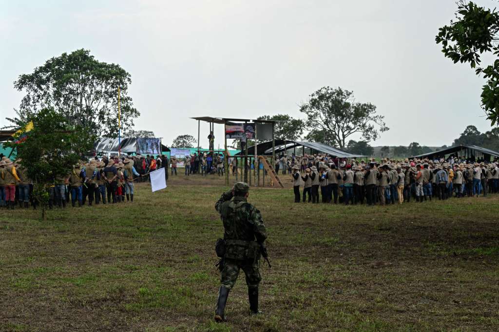 Un combatiente de la disidencia de las FARC EP camina como miembros de la Guardia Campesina durante una reunión con las comunidades locales en San Vicente del Caguán, a donde los comandantes guerrilleros anunciarán a sus negociadores de paz con el Gobierno.
