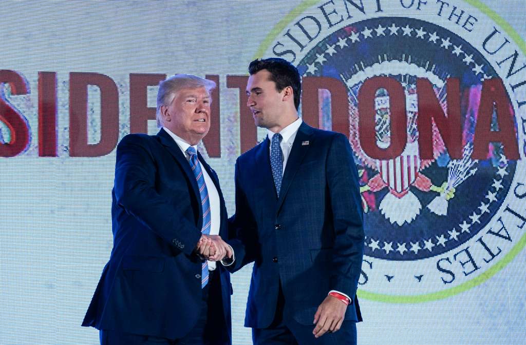 (FILES) US President Donald Trump shakes hands with Charlie Kirk, head of Turning Point USA, before addressing the Turning Point USA’s Teen Student Action Summit in Washington, DC, on July 23, 2019.