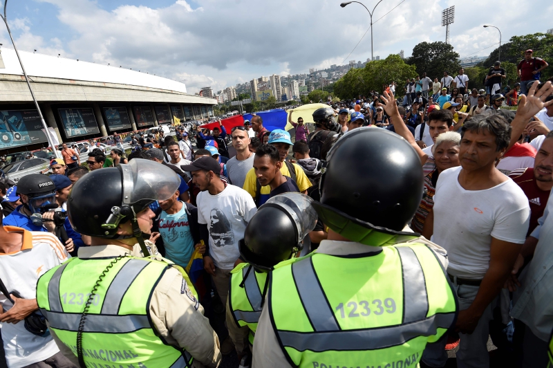 Policías custodiaron la marcha de miles de opositores en Caracas. / AFP