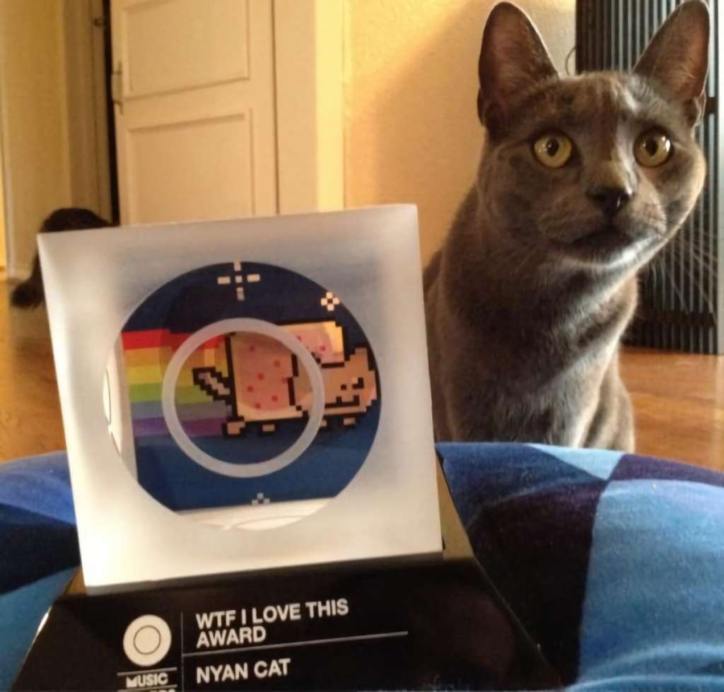 ACOMPAÑA CRÓNICA: EEU ARTE***USA8273. NUEVA YORK (NY, EEUU), 05/06/2022.- Fotografía personal cedida hoy por Chris Torres donde aparece su gato junto a un premio ganado por el gato Nyan, un meme que ahora la comunidad de internet considera un icono del siglo XXI, y que se ha vendido por más de 600.000 dólares. Los GIFs y los memes que los usuarios comenzaron a intercambiar a modo de broma en internet están adquiriendo un importante valor de mercado y empiezan a recaudar millones entre los coleccionistas. EFE/Álbum Chris Torres /SOLO USO EDITORIAL/NO VENTAS/SOLO DISPONIBLE PARA ILUSTRAR LA NOTICIA QUE ACOMPAÑA/CRÉDITO OBLIGATORIO