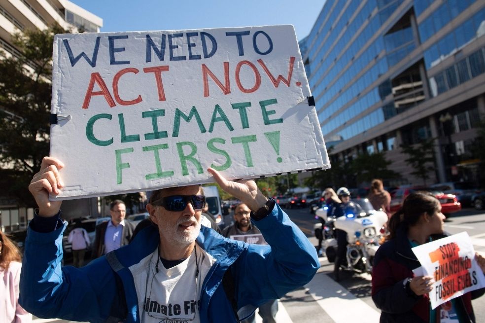 Manifestantes protestan por las inversiones del FMI y el Banco Mundial en combustibles fósiles y los instan a enfrentar el cambio climático.