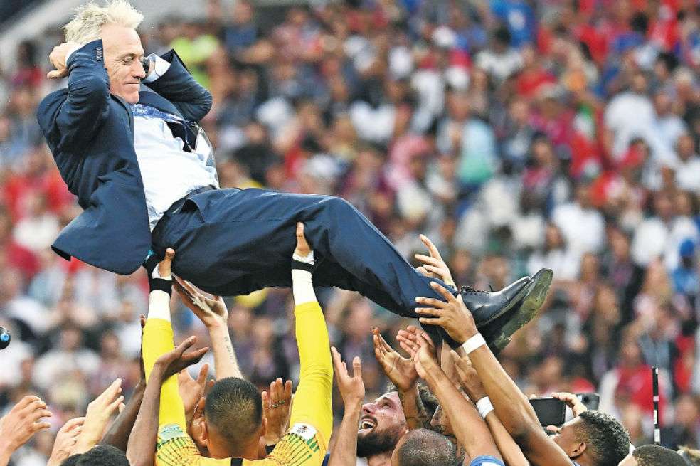 Los jugadores franceses festejan con su técnico, Didier Deschamps. Después, en la rueda de prensa, lo bañaron en champaña. / AFP