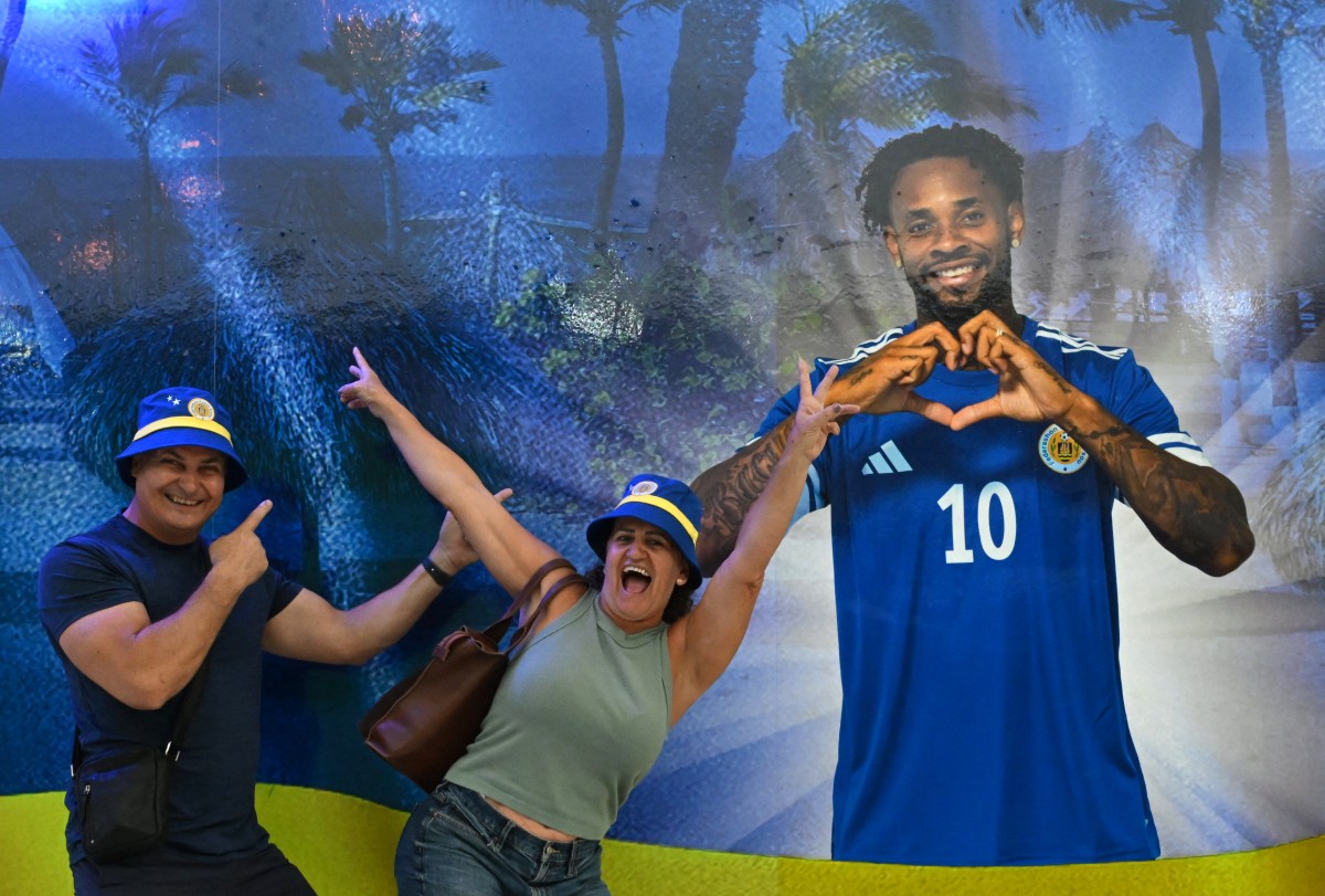 People pose with an image of Curacao's player Leandro Bacuna at the official fan store in Willemstad, Curacao, in the Dutch Caribbean, on April 8, 2026.