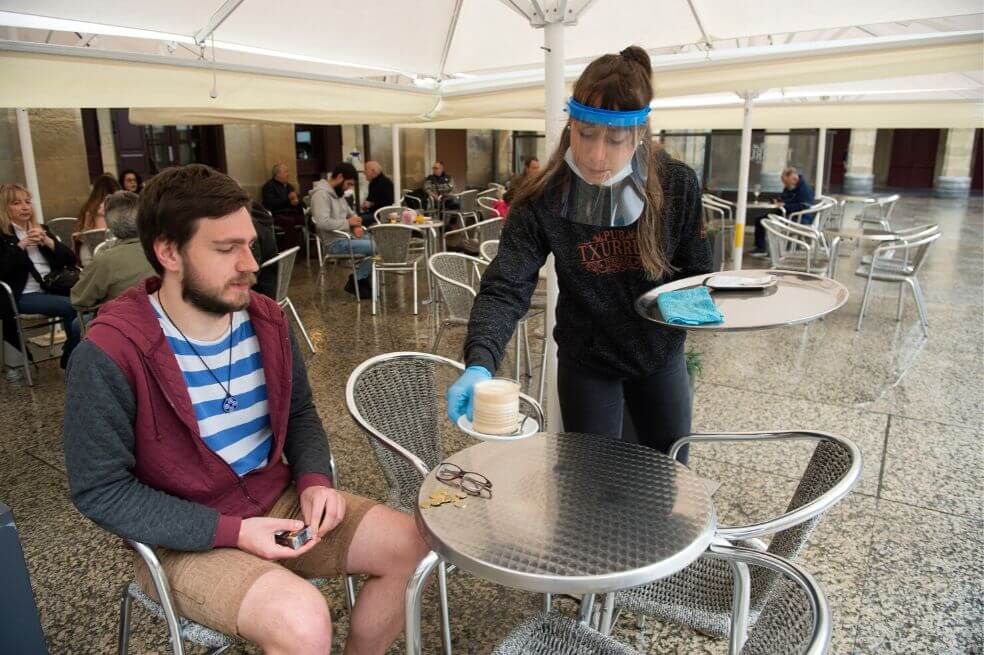 Un empleado sirve café con una máscara facial y guantes en una cafetería en la ciudad vasca española de San Sebastián, mientras España avanzaba para aliviar su estricto encierro en ciertas regiones.
/ Ander Gillenea / AFP