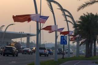 US and Qatar flags flutter on a main road in Doha on May 13, 2025, ahead of a visit by US President Donald Trump.